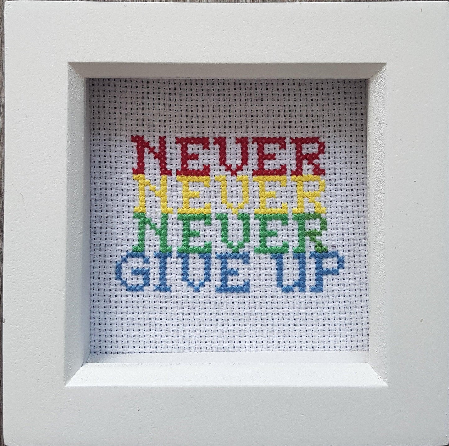 Never give up, completed cross stitch quote